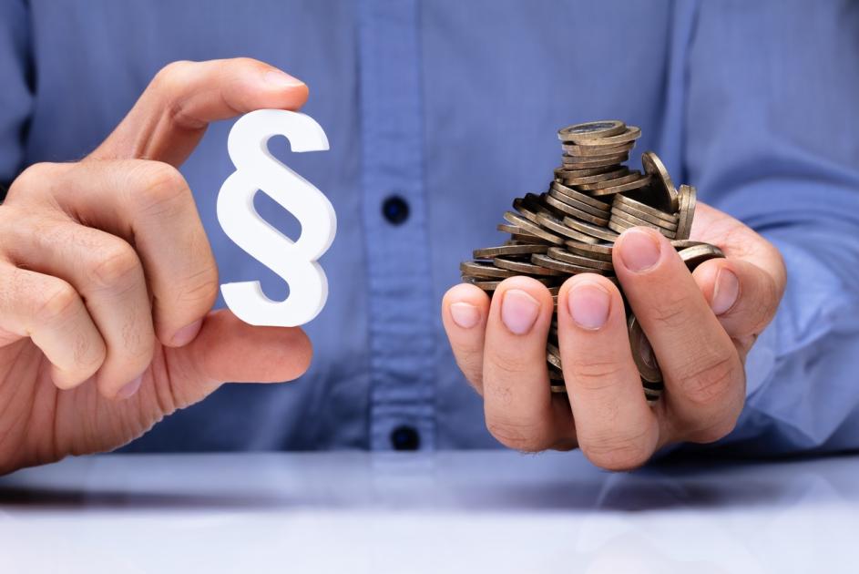 Hände mit Paragraphenzeichen und Geld