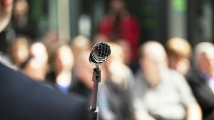 Person steht vor Mikrofon