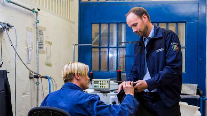 Inhaftierter und Mitarbeiter einer JVA bei der Arbeit